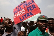 A protester holds a sign which reads 'Leave fuel price N(aira) 65 per litre' in a crowd of demonstrators protesting against the removal of a fuel subsidy by the Nigerian government. Credit: George Osodi / Panos