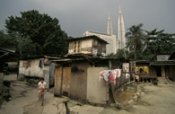 Luxury hotels and offices rise behind slum housing in centre of Malaysia. Mark Henley/Panos