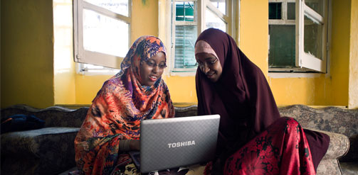 Image: 'Somalia, Mogadishu. Two students from Mogadishu University use a laptop as they study at home.' (Sven Torfinn / Panos)