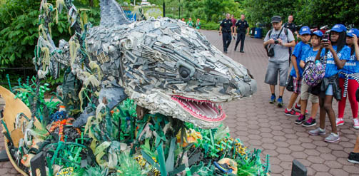 A large sculpture of a shark made out of plastic waste found in the ocean.