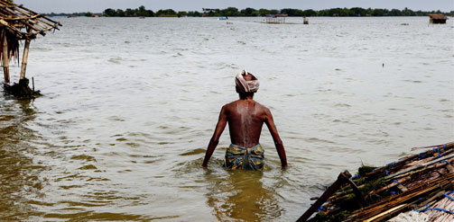 This is the image of a man in Bangladesh whose house has been flooded.