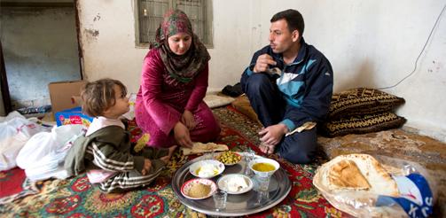 Providing food vouchers in Lebanon to Syrian refugees. Wafa gives her 2-year-old daughter and her husband some of the bread, olives and humus she bought earlier today with her vouchers. Credit: Photo credit: WFP/Rein Skullerud. European Commission DG ECHO's photostream on Flickr.