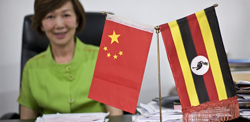 Madam Fang, the manager and owner of Hotel Fang Fang in Kampala, and chairperson of an organisation for Chinese investors in Uganda. On her desk sit the flags of Uganda and China. Credit: Sven Torfinn / Panos