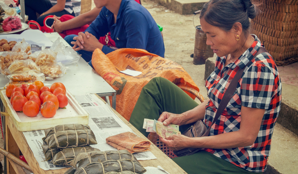 A market vendor is counting the day's earnings.