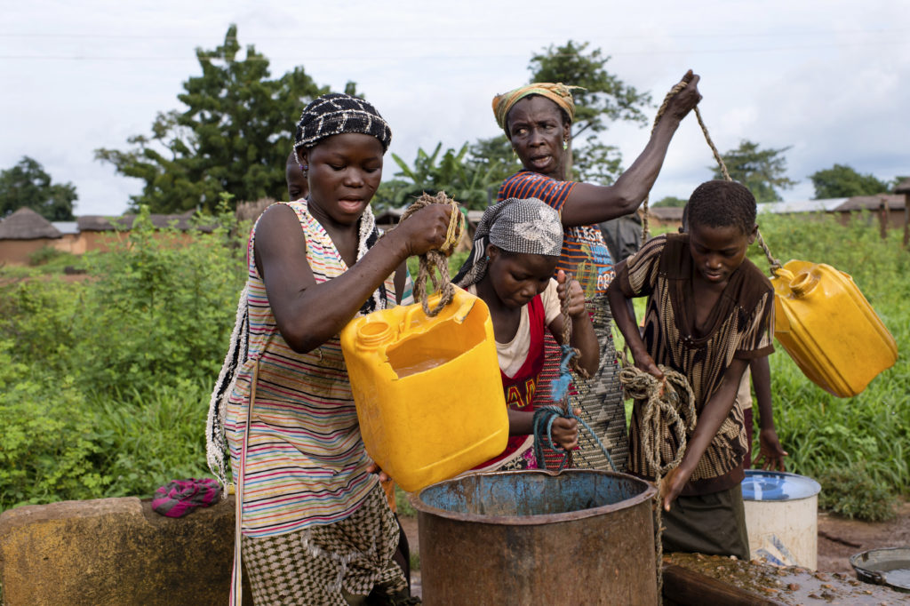 Women and girls collecting water from a well in the village of Nyologu.