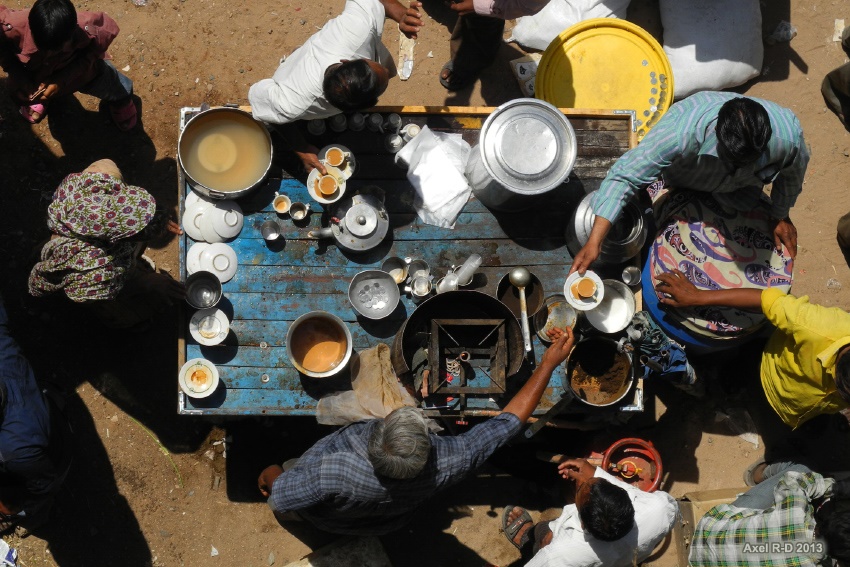 Men around a table drinking Chai tea in a Chai shop in India 