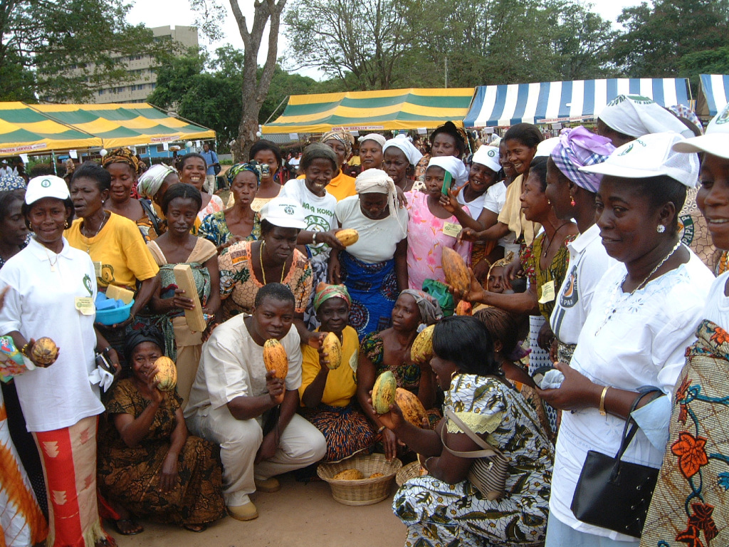 Farmers of Kuapa Cocoa co-operative gather for a photo holding their produce