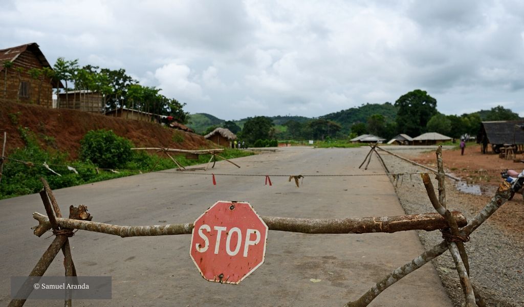 A stop sign hangs on a makeshift barrier that closes a road leading into the quarantine area near the town of Kenema, eastern Sierra Leone.