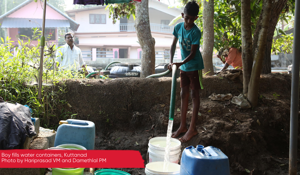 A boy fills a bucket with water from a pipe, Kuttanad