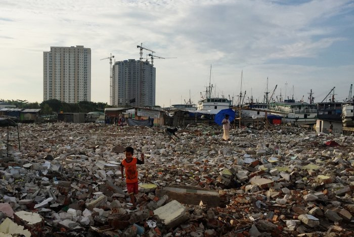 A recently demolished 'kampung' or informal village in North Jakarta. The former residents of Pasar Ikan Penjaringan (which literally means Penjaringan fish market) say they were given one week's notice before their houses were reduced to rubble. In the background, new high-rises are under construction in the coastal community of Muaru Baru