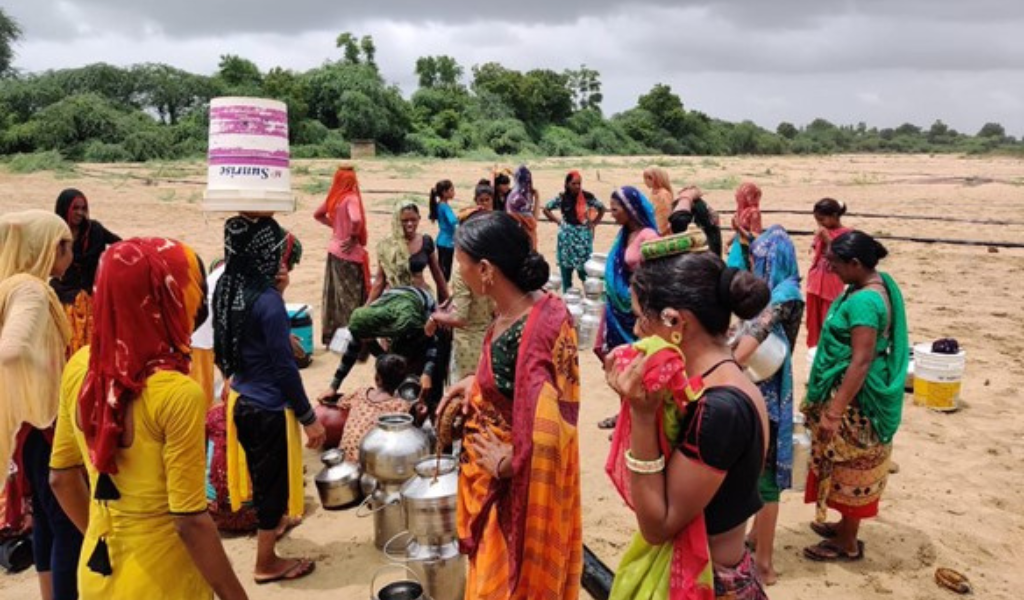 Women gathering drinking water in large containers 