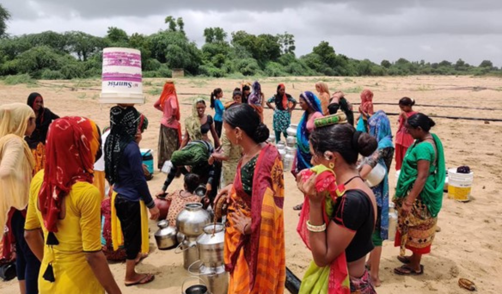 Women gathering drinking water in large containers