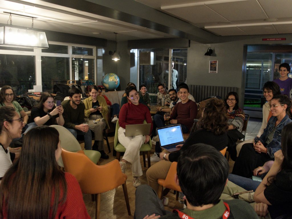 Members of the University of Sussex Latin American Society sit in a circle and have a conversation in the IDS bar. 