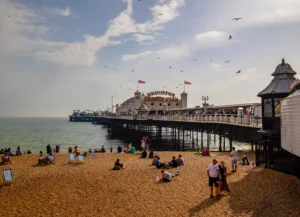 People on Brighton beach with pier in the background