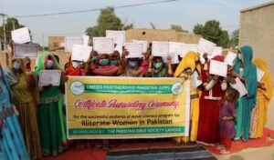 Women holding up a banner and their certificates