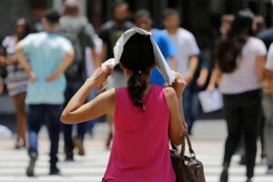 Woman covering her head with a paper to protect herself from heat