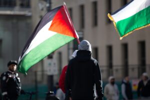 A person holding the Palestinian flag at a protest