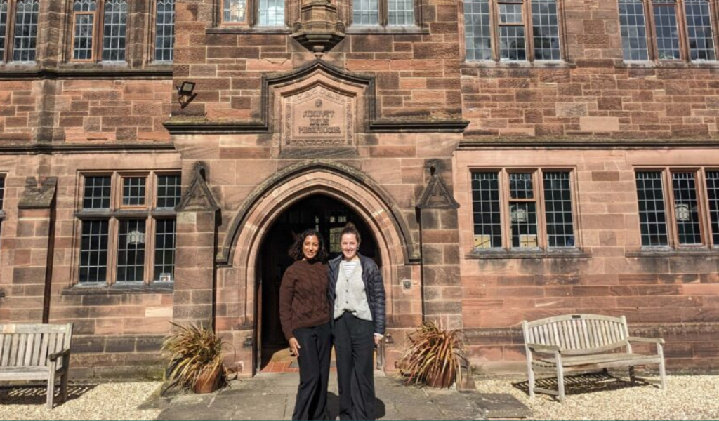 Adrienne Lees and Sripriya Srivatsa standing in front of the library