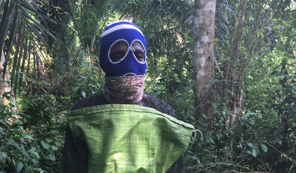 Man wearing homemade personal protective equipment, against a background of trees