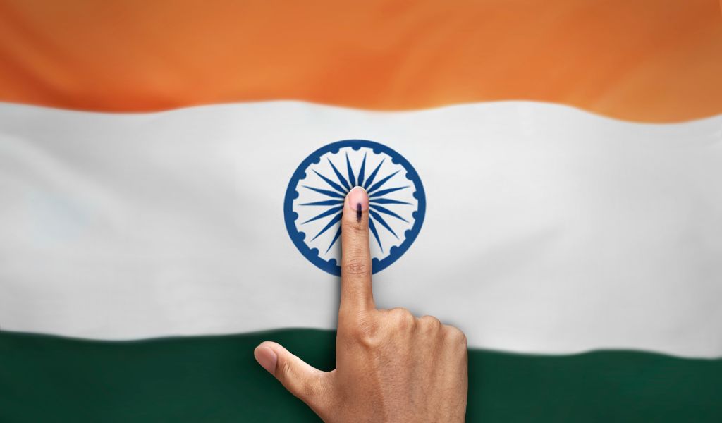 female Indian Voter Hand with voting sign or ink pointing vote for India on india flag background