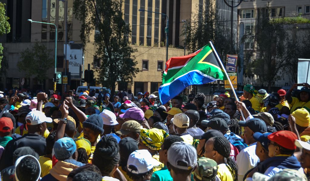south african flag waved above the heads of protesters at a political rally midday johannesburg
