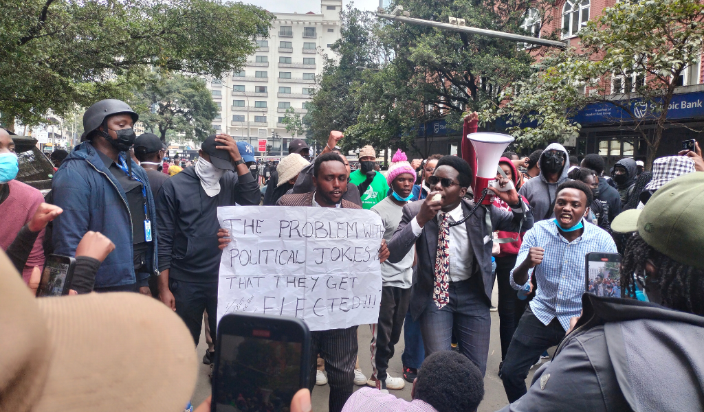 Photo shows protesters out on the streets in Nairobi, Kenya. One protester stands out in the crowd, holding a placard that reads: "The problem with political jokes is that they get elected!!!"