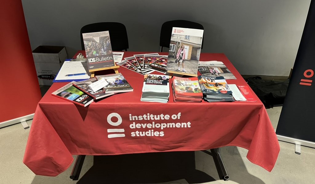 A table with a red covering, and a variety of publications and flyers on it.