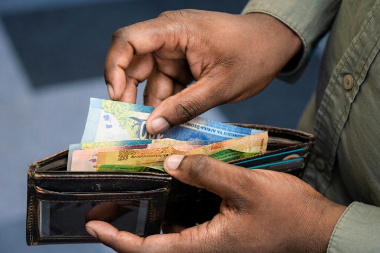 Close up of a person's hands pulling notes out of a wallet.