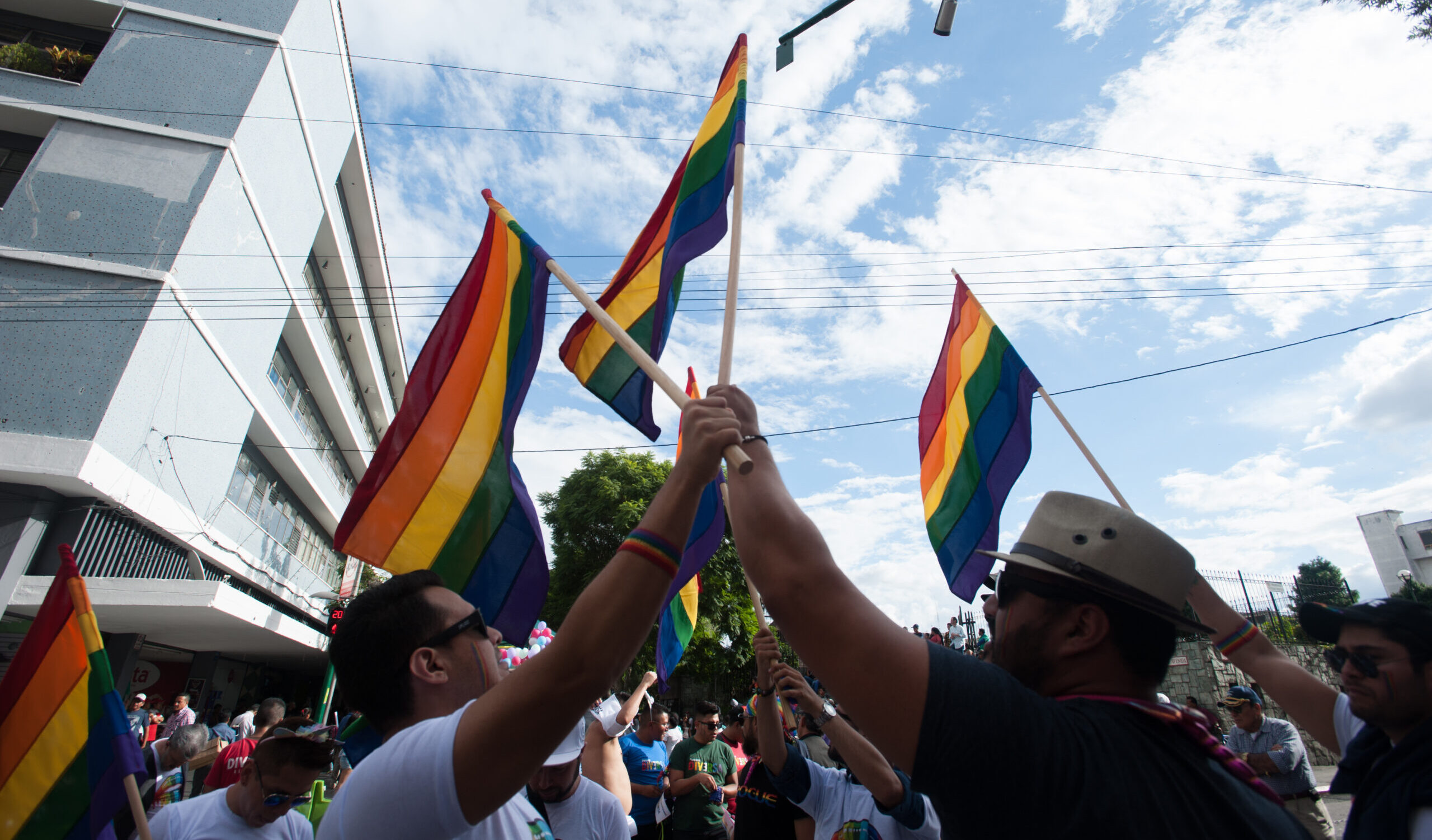 Pride Parade participants march down a street waving pride flags in Guatemala City July 20, 2019.