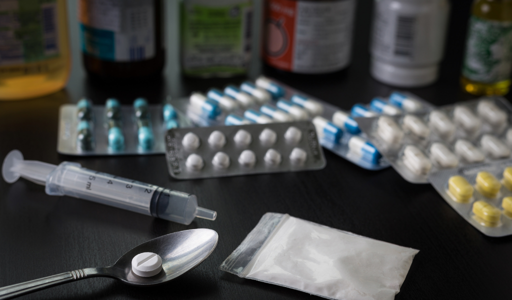 Different colour medicines and a syringe on a table