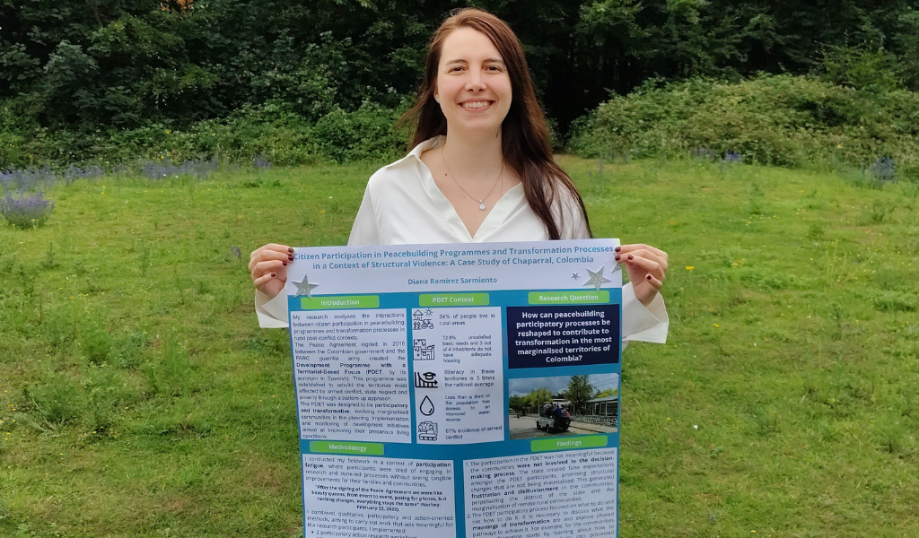 PhD researcher holding a poster 