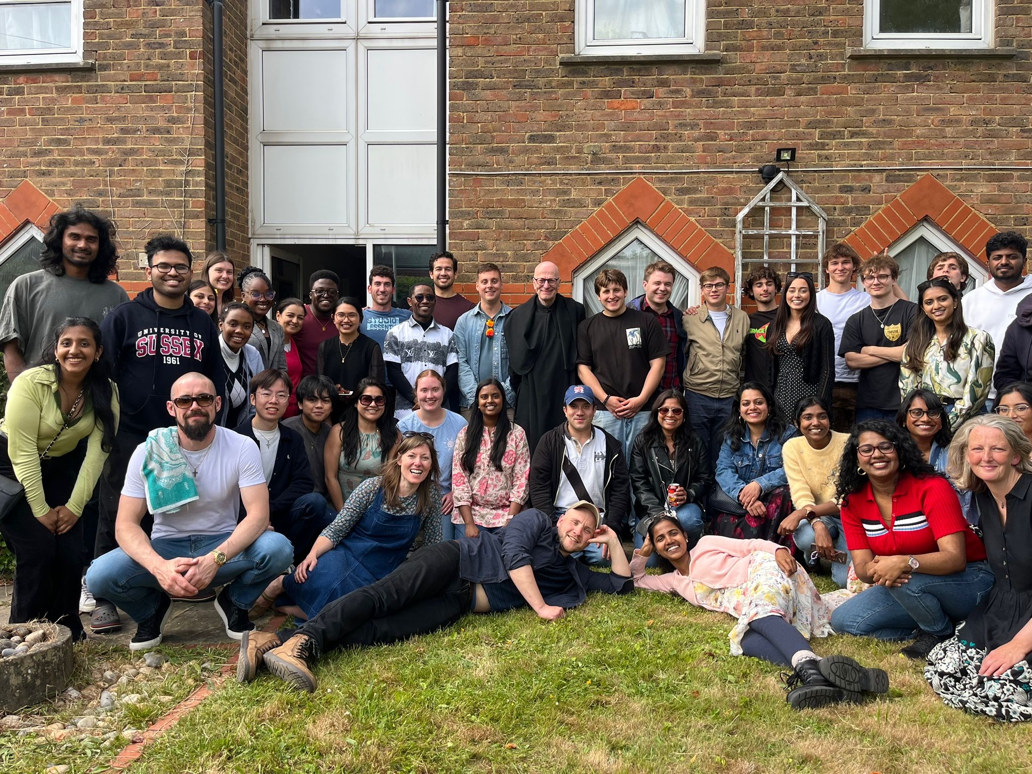 A large group of people posing for a photo outside during the day. 