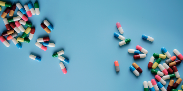 Top view colorful antibiotic capsule pills on blue background