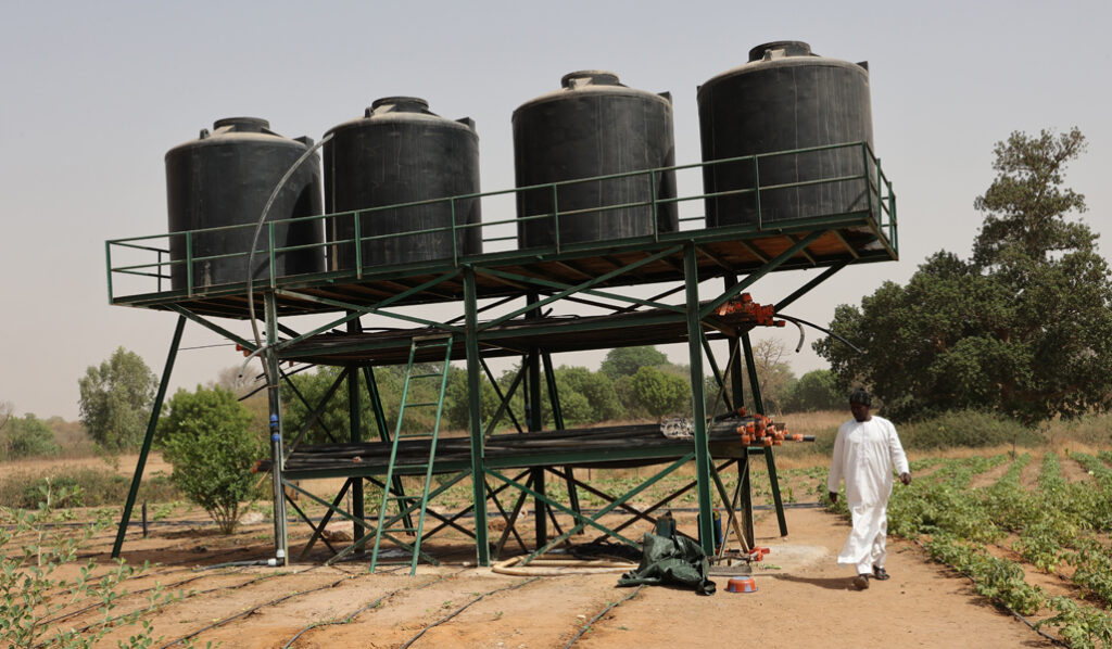 Paoskoto Kaolack region Sénégal, 26 april 2024 : Field equipped with a drip irrigation system, with a pump and solar panels drawing water through a well and a borehole. Agricultural rural activities.