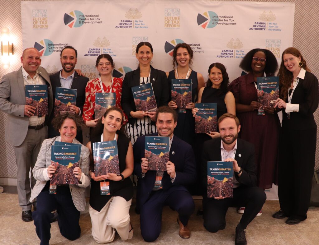 A group photo of members of the ICTD team holding copies of the report. 